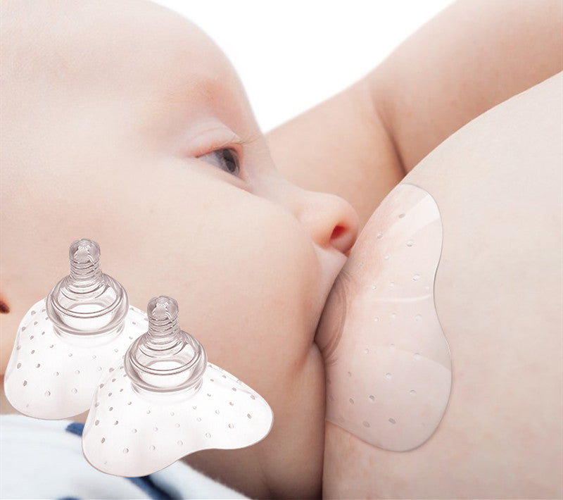 A baby sucks from a woman's breast through a nipple shield