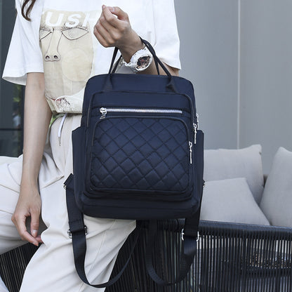 women hold the Oxford Cloth Backpack with one hand